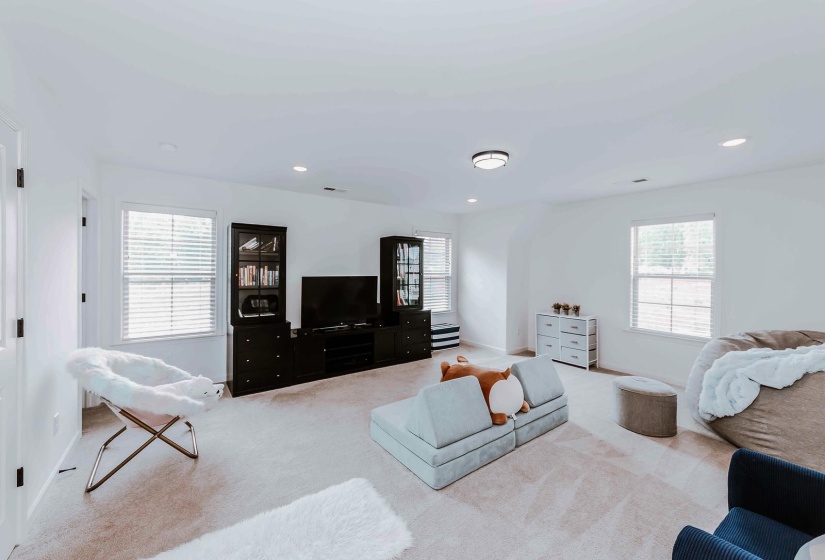 Living room with carpet flooring, recessed lighting, and baseboards