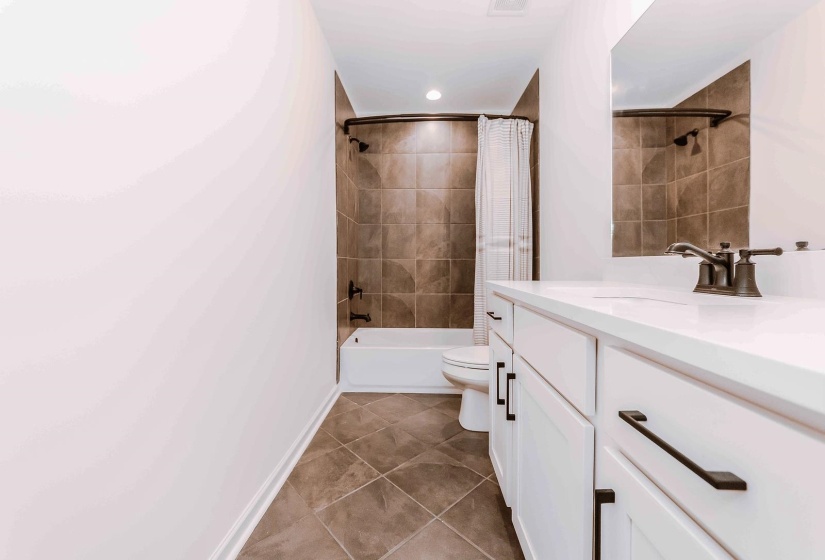 Bathroom featuring vanity, tile patterned flooring, toilet, bathtub / shower combination, and recessed lighting
