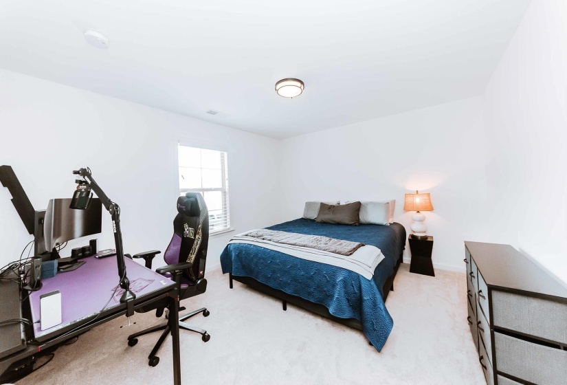 Bedroom with baseboards and light carpet