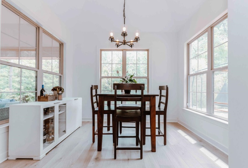 Dining room with baseboards, a chandelier, and light wood finished floors