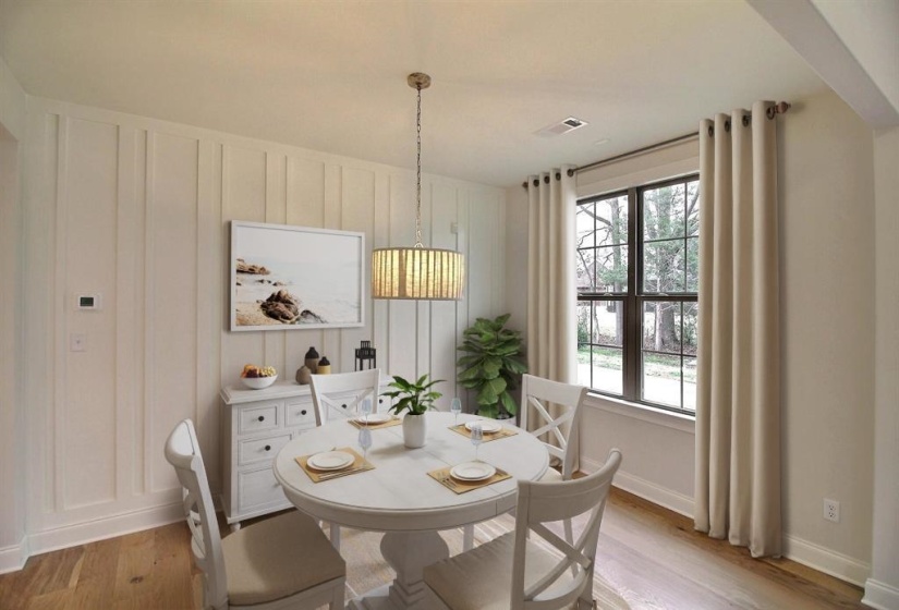 Dining space featuring light wood-type flooring and a decorative wall