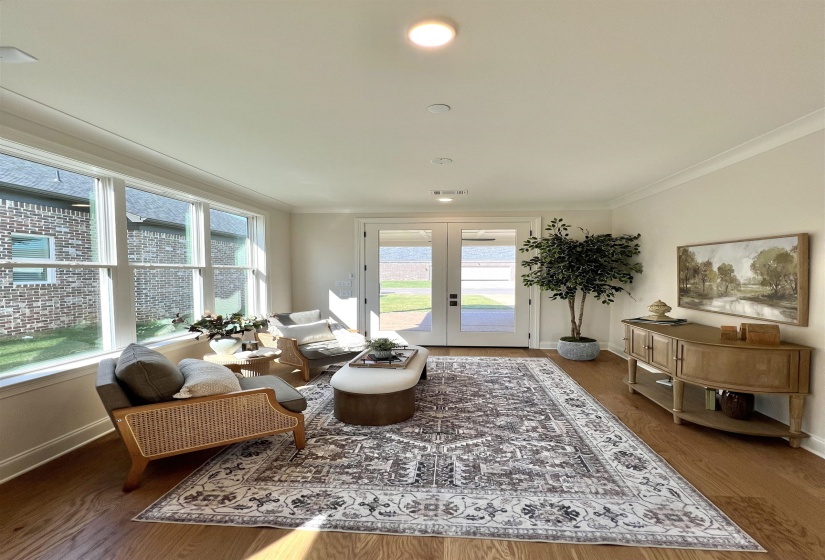 Living area featuring french doors, wood finished floors, crown molding, and recessed lighting