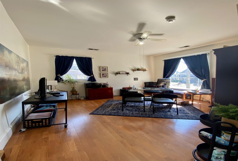 Interior space featuring visible vents, a ceiling fan, wood finished floors, and a wealth of natural light