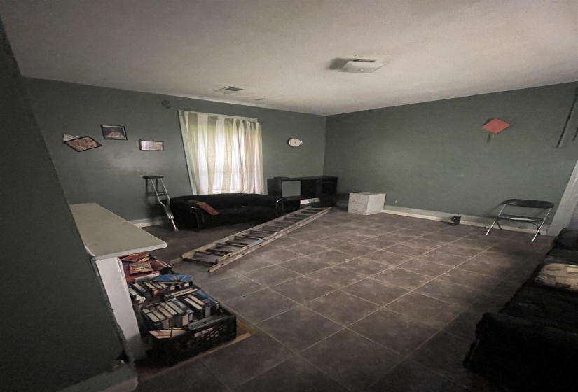 Living area featuring visible vents and dark tile patterned flooring