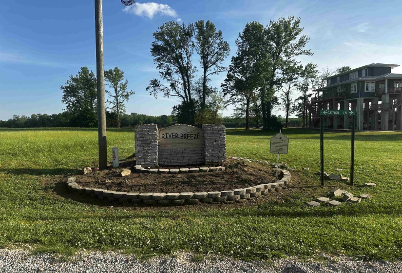 Community / neighborhood sign featuring a yard