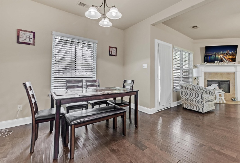 Dining room with an inviting chandelier, baseboards, visible vents, and dark wood finished floors