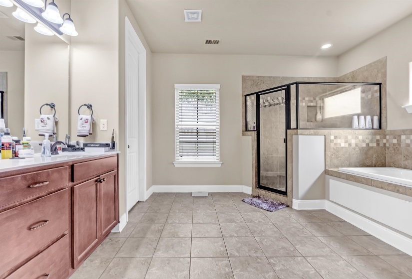 Full bath with a garden tub, visible vents, tile patterned flooring, and vanity