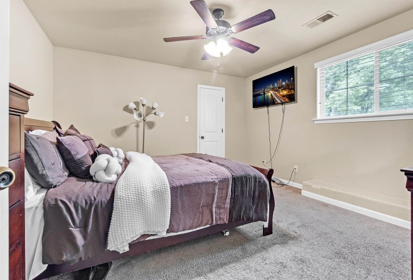 Bedroom featuring baseboards, carpet flooring, visible vents, and a ceiling fan
