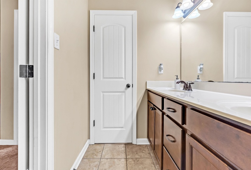 Bathroom with a sink, double vanity, and baseboards