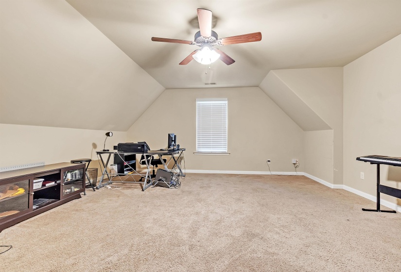 Exercise room with carpet flooring, baseboards, lofted ceiling, and a ceiling fan