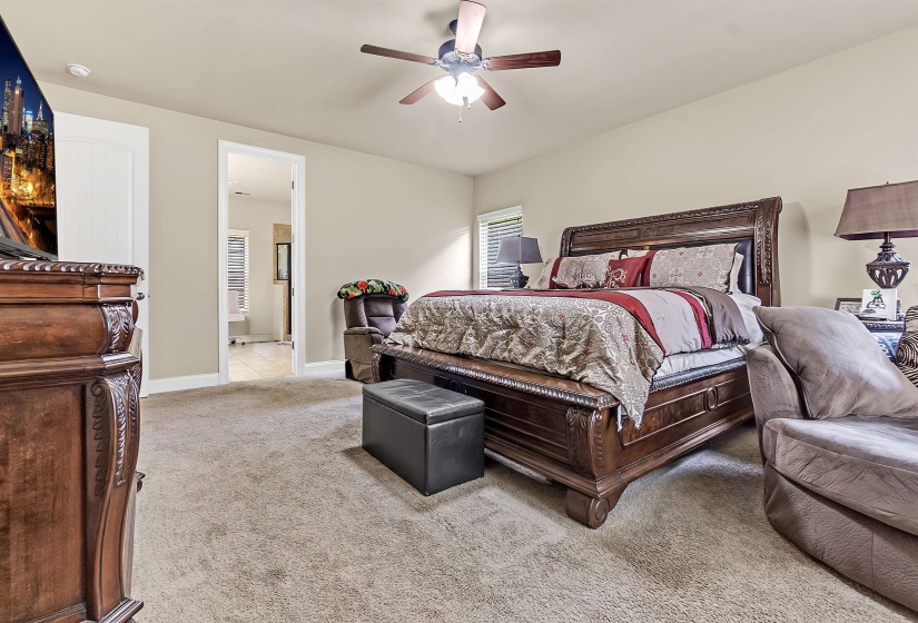 Carpeted bedroom featuring baseboards and ceiling fan