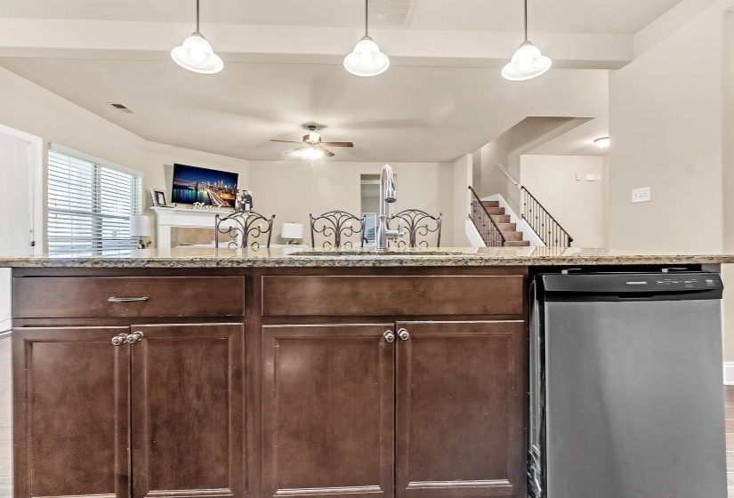 Kitchen with a sink, stainless steel dishwasher, a ceiling fan, and dark brown cabinets