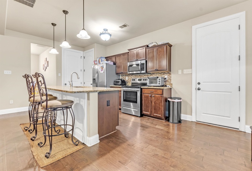 Kitchen featuring a breakfast bar area, baseboards, visible vents, a sink, and stainless steel appliances