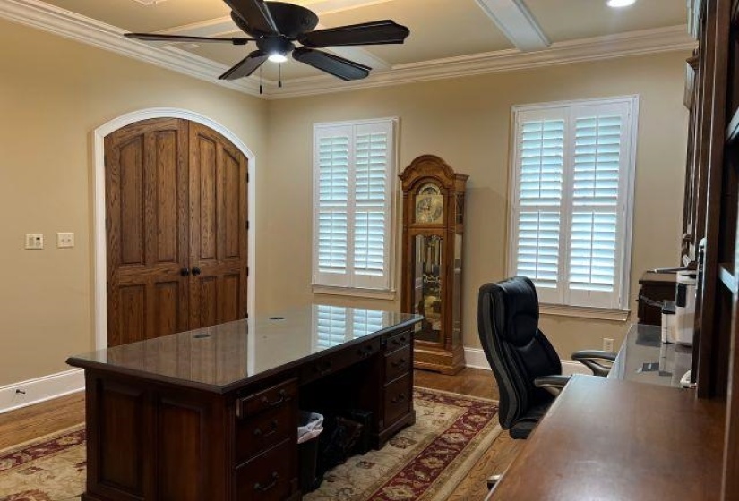 Home office featuring ceiling fan, crown molding, baseboards, and light wood finished floors