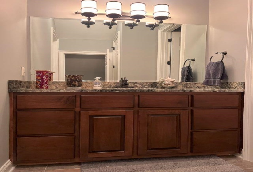 Bathroom with tile patterned flooring, an inviting chandelier, and vanity