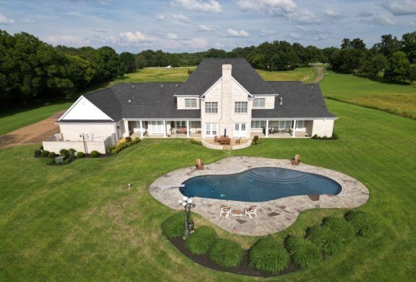 Rear view of house featuring a patio, a lawn, an outdoor pool, and a chimney