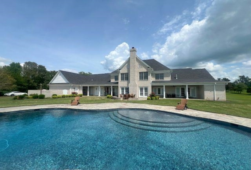 Pool with a lawn and a patio area
