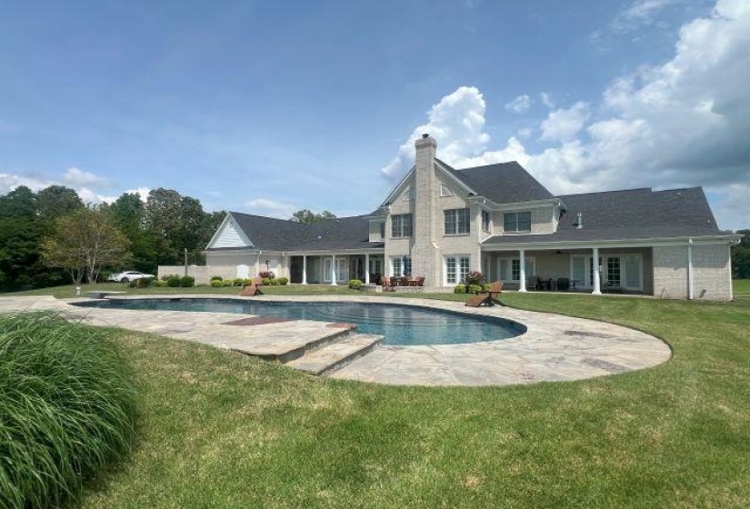 Outdoor pool with a yard, a patio, and a diving board