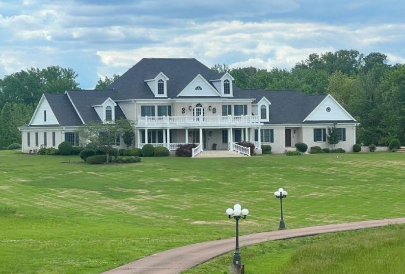 View of front of home featuring a balcony, a front yard, and a porch