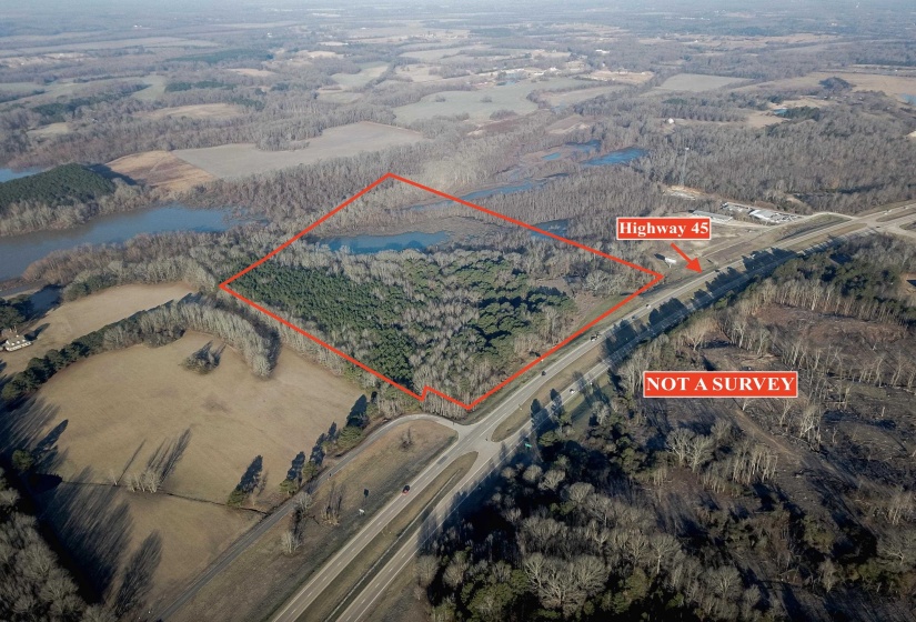 Aerial view of sparsely populated area featuring property parcel outlined and a nearby body of water