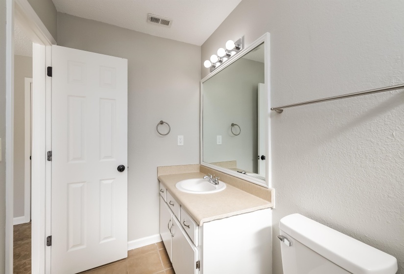 Bathroom featuring tile flooring, oversized vanity, and toilet