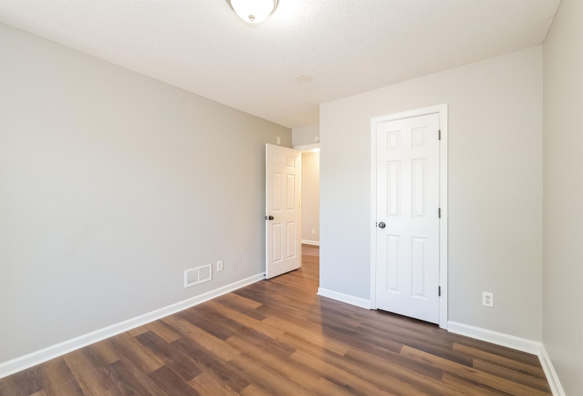 Unfurnished bedroom featuring a closet and dark wood-type flooring