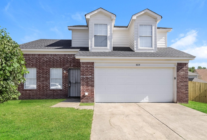 View of front of property with a garage and a front yard