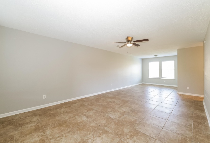 Tiled spare room featuring ceiling fan