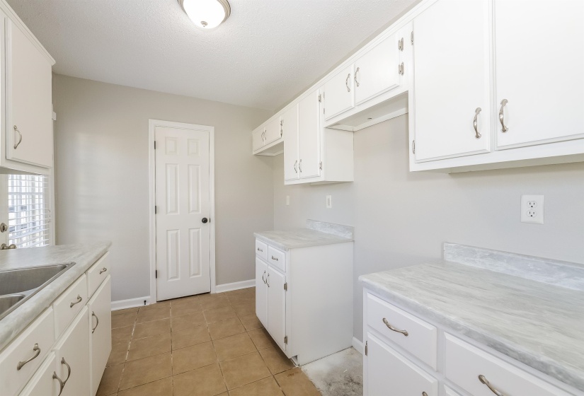 Kitchen featuring white cabinetry and light tile floors