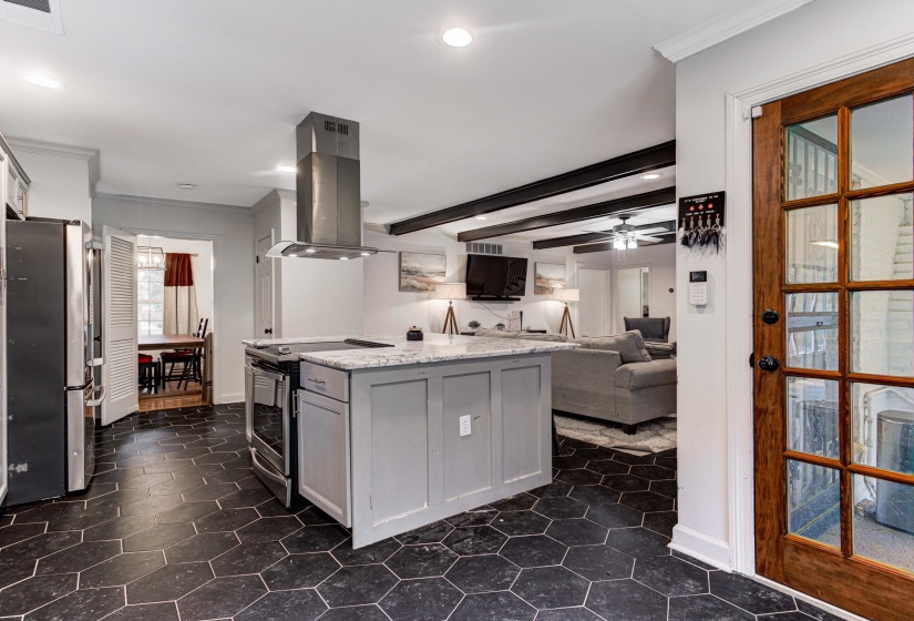 Kitchen with island exhaust hood, appliances with stainless steel finishes, ornamental molding, recessed lighting, and baseboards