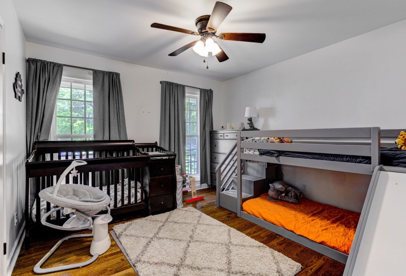 Bedroom with multiple windows, wood finished floors, and a ceiling fan
