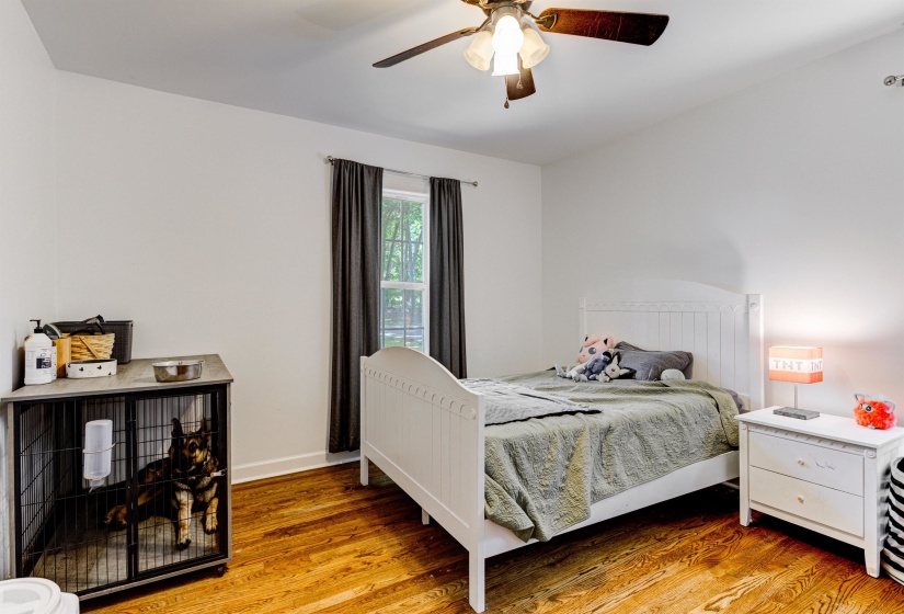 Bedroom with wood finished floors, a ceiling fan, and baseboards