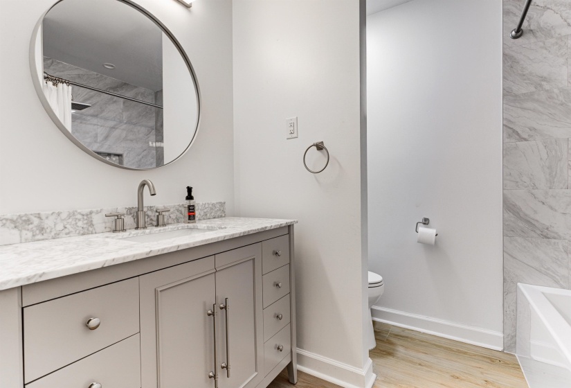 Bathroom featuring wood finished floors, toilet, vanity, and baseboards