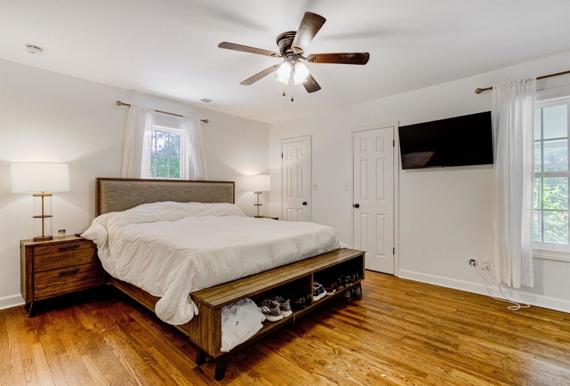 Bedroom with multiple windows, wood finished floors, and baseboards