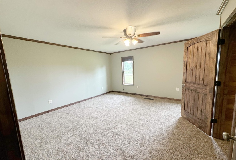Unfurnished bedroom featuring carpet, crown molding, baseboards, and ceiling fan