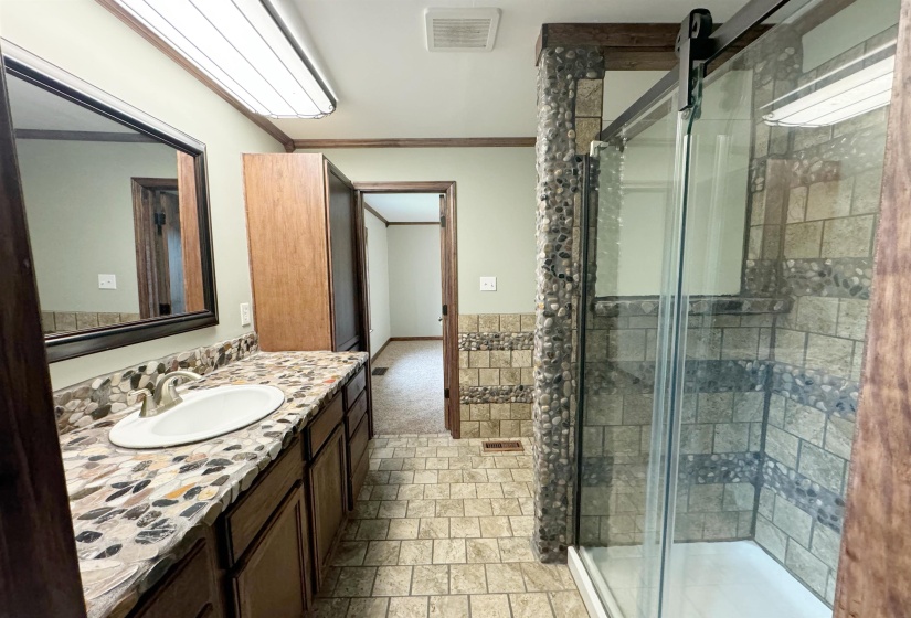 Bathroom featuring a stall shower, vanity, and ornamental molding