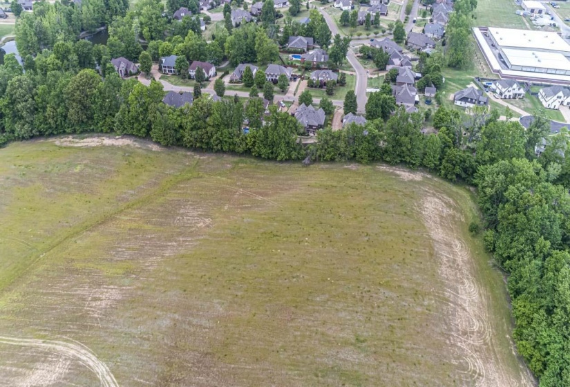 Aerial view of property's location with a tree filled landscape