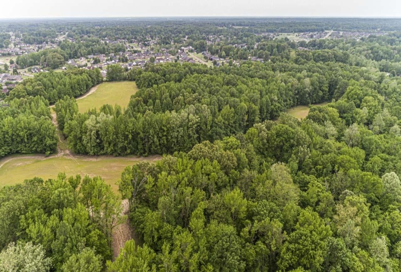Aerial view of property and surrounding area featuring a heavily wooded area