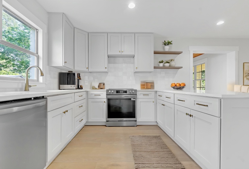 Kitchen with appliances with stainless steel finishes, recessed lighting, light countertops, backsplash, and open shelves