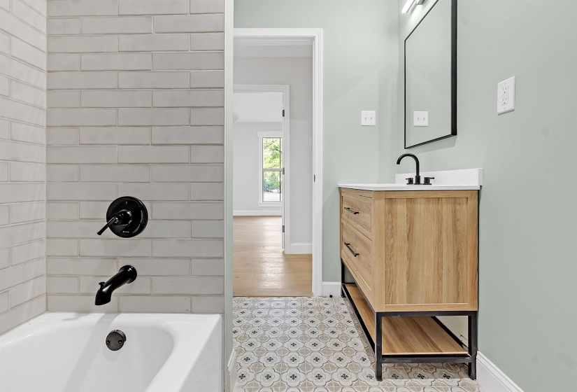Full bathroom with vanity, bathtub / shower combination, and baseboards