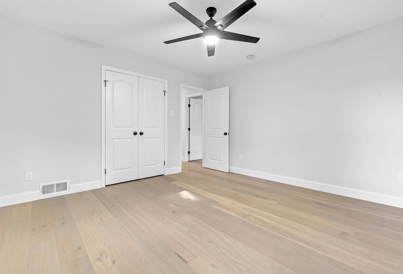 Unfurnished bedroom featuring baseboards, light wood-style floors, ceiling fan, and a closet