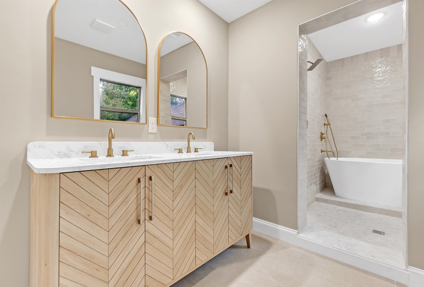 Full bath with tiled shower, double vanity, baseboards, tile patterned floors, and a freestanding bath