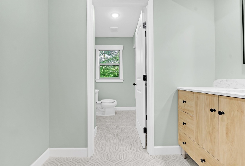Bathroom with toilet, vanity, baseboards, and tile patterned flooring