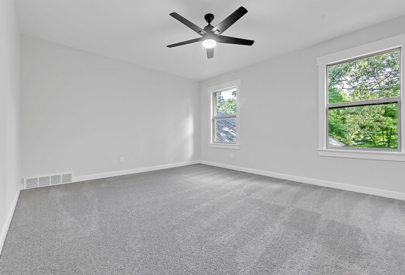 Carpeted empty room featuring baseboards and ceiling fan