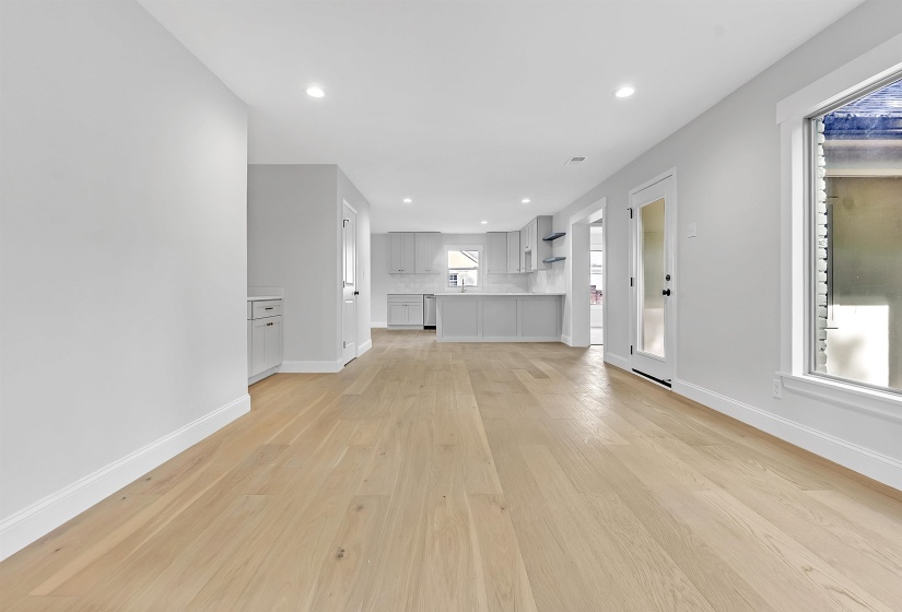 Unfurnished living room with light wood-style flooring, baseboards, and recessed lighting
