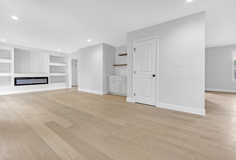 Unfurnished living room with baseboards, light wood-style floors, built in features, and recessed lighting