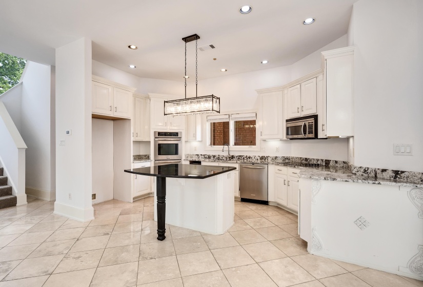 Kitchen with stainless steel appliances, recessed lighting, a breakfast bar area, a kitchen island, and pendant lighting