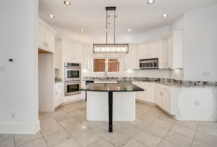 Kitchen with stainless steel appliances, a sink, decorative light fixtures, a center island, and recessed lighting
