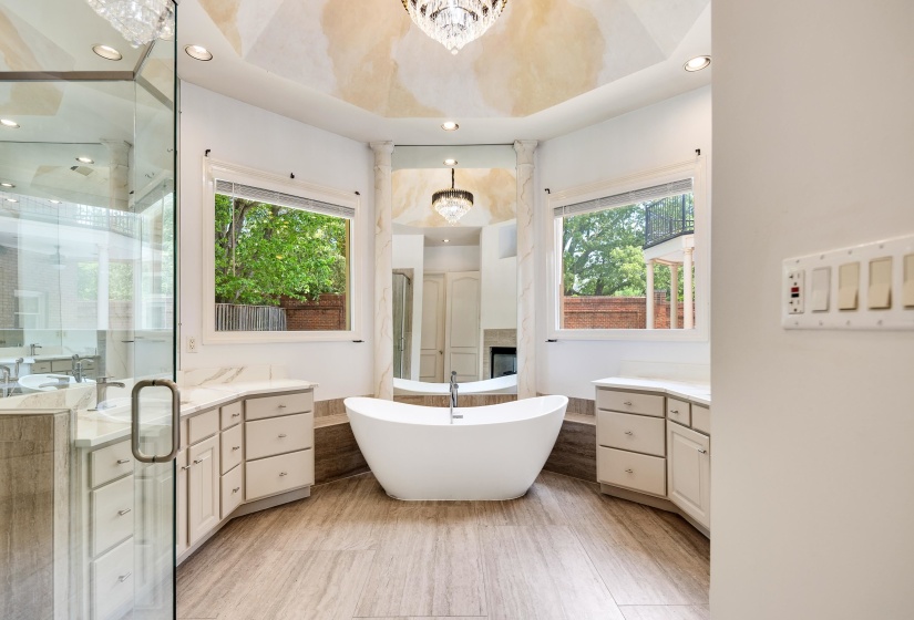 Bathroom featuring a shower stall, a freestanding tub, a chandelier, recessed lighting, and vanity