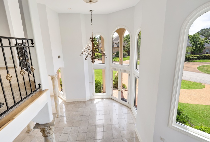 Foyer with a high ceiling, baseboards, and light tile patterned floors